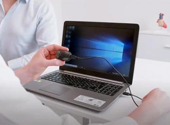 Person connecting a long-term ECG device to a laptop for data transfer.