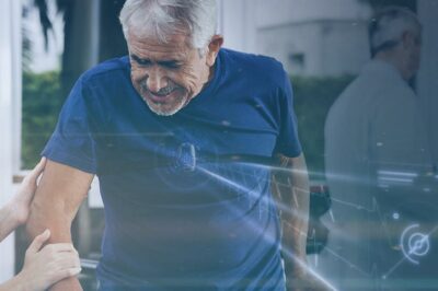 Healthcare worker assisting an elderly man with physical therapy, using parallel bars for rehabilitation.