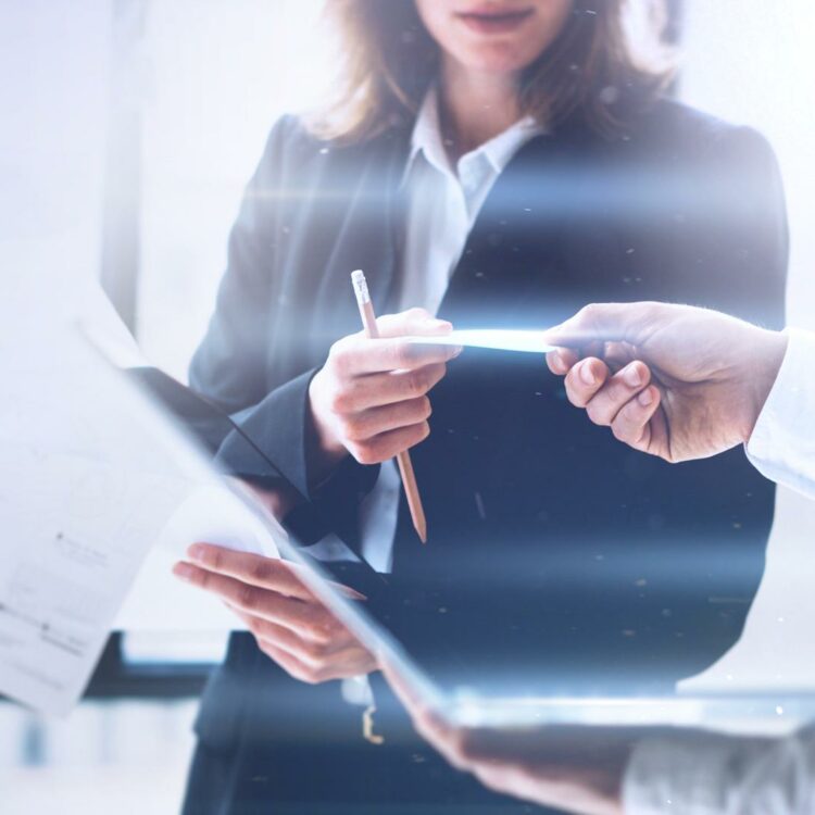 Business professionals exchanging documents during a discussion