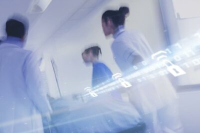 Healthcare workers moving through a hospital corridor with digital overlays of padlocks and binary code, symbolizing secure data transmission in wireless medical devices.